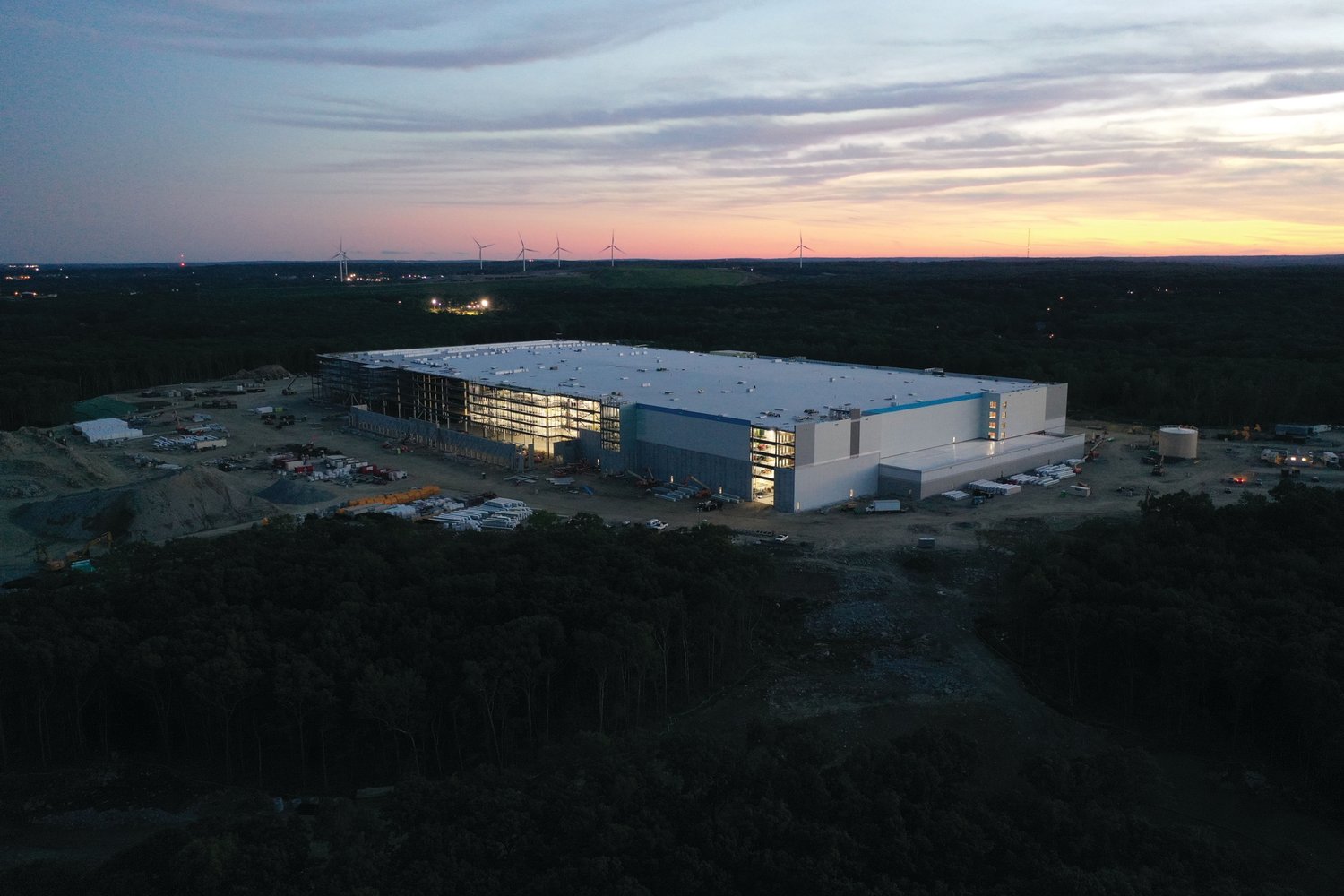 RIBBON CUTTING? According to Caitlin McLaughlin, Amazon Public Relations New England, the facility’s completion date is scheduled for the “second half of 2023.” The $290 million project is visible from points across the region, as crews work through the night.